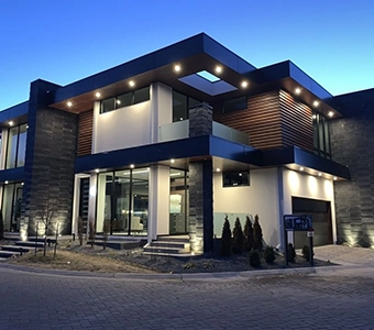 Modern luxury home with large windows and exterior lighting at dusk.